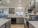 Well-lit kitchen with gray cabinetry, stainless steel appliances, and wood-look tile flooring for a modern, clean aesthetic at 2550 E Caballero St, Mesa, AZ 85213