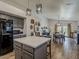 Open kitchen with gray cabinets, stainless steel appliances, wood-look tile flooring and a view into the dining area at 2550 E Caballero St, Mesa, AZ 85213
