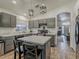 Modern kitchen with gray cabinets, stainless steel appliances, an island with seating, and wood-look tile flooring at 2550 E Caballero St, Mesa, AZ 85213