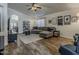Spacious living room with a large sectional couch, ceiling fan, hardwood floors, and bright natural light at 2550 E Caballero St, Mesa, AZ 85213