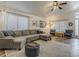 Cozy living room showcasing hardwood floors, a sectional sofa, and large windows for ample natural light at 2550 E Caballero St, Mesa, AZ 85213