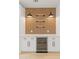 Kitchen beverage station features a beverage cooler, white cabinets, countertop, vertical wood paneling, and stylish wall-mounted lighting at 3221 N 37Th St # 26, Phoenix, AZ 85018