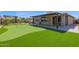 Enjoy outdoor living with a putting green, covered patio, and lush landscaping at 3498 E Ravenswood Dr, Gilbert, AZ 85298