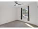Comfortable bedroom featuring a ceiling fan, cozy carpet, and natural lighting at 3498 E Ravenswood Dr, Gilbert, AZ 85298