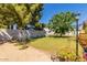 Well-maintained backyard featuring lush green grass, mature shade trees, and a decorative garden trellis at 3554 W Aire Libre Ave, Phoenix, AZ 85053