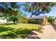 Large backyard with mature trees, grass, and a yellow home; perfect for entertaining or enjoying the outdoors at 3554 W Aire Libre Ave, Phoenix, AZ 85053
