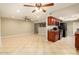 Open-concept living room featuring tile flooring, ceiling fans and adjoining kitchen area at 3554 W Aire Libre Ave, Phoenix, AZ 85053