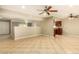 Open-concept living room with chandelier and tile flooring, flowing to kitchen at 3554 W Aire Libre Ave, Phoenix, AZ 85053