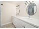 Bathroom featuring double sinks, modern lighting, round mirrors, and white shaker cabinets at 3824 W Carol Ave, Phoenix, AZ 85051
