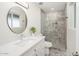 Modern bathroom features a sleek vanity, decorative mirror, and a stylish tiled walk-in shower at 3824 W Carol Ave, Phoenix, AZ 85051