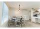 Bright dining area with wooden table and four chairs, complemented by modern lighting fixture and coffee bar at 3824 W Carol Ave, Phoenix, AZ 85051