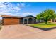 Single-story home with a charming brick archway, green lawn, and a large driveway at 3824 W Carol Ave, Phoenix, AZ 85051