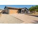 Wide shot showing the home's garage, driveway, and modern, painted brick exterior with beautiful desert landscaping at 3824 W Carol Ave, Phoenix, AZ 85051