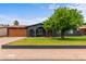 Charming single-story home featuring a well-maintained lawn, mature tree, and an attached garage at 3824 W Carol Ave, Phoenix, AZ 85051
