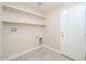 Laundry room with tiled floor, utility connections, shelves and a white door at 3824 W Carol Ave, Phoenix, AZ 85051