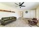 Spacious living room with tile floors, leather seating, shelf decor, and a modern ceiling fan at 3824 W Carol Ave, Phoenix, AZ 85051