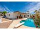 Inviting backyard with a sparkling pool, covered patio, and a lush garden under a clear sky at 3951 E Sequoia Trl, Phoenix, AZ 85044