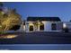 Charming home exterior featuring a dark tile roof, arched windows, and illuminated landscaping at twilight at 3951 E Sequoia Trl, Phoenix, AZ 85044
