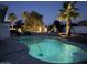 Backyard featuring a sparkling pool with diving board, palm trees, and playset under the night sky at 3951 E Sequoia Trl, Phoenix, AZ 85044