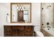 Elegant bathroom with a wooden vanity, framed mirror, and tiled shower at 40853 N 94Th St, Scottsdale, AZ 85262