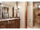 Bathroom with granite countertops, wood cabinetry, and a glass shower at 40853 N 94Th St, Scottsdale, AZ 85262