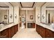 Bright bathroom featuring dual sinks, stone countertops, mini bar, and decorative sconces, exuding luxury at 40853 N 94Th St, Scottsdale, AZ 85262