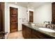 Bathroom with dual sinks, granite countertops, and dark wood cabinetry at 40853 N 94Th St, Scottsdale, AZ 85262
