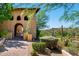 Inviting arched entryway framed by lush greenery and a desert landscape backdrop at 40853 N 94Th St, Scottsdale, AZ 85262