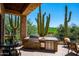 Outdoor kitchen area featuring stainless steel grill, sink, refrigerator and beautiful desert views at 40853 N 94Th St, Scottsdale, AZ 85262