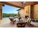 Inviting outdoor seating area with a stone fireplace, overlooking the pool and golf course at 40853 N 94Th St, Scottsdale, AZ 85262