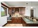 Home wet bar featuring granite counters, tiled backsplash, and wooden cabinets at 40853 N 94Th St, Scottsdale, AZ 85262