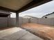 The backyard features a cinder block wall, and covered patio with an exposed aggregate concrete surface at 46886 W Coe St, Maricopa, AZ 85139