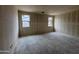 Spacious bedroom featuring drywall, concrete floors, and two bright windows at 46886 W Coe St, Maricopa, AZ 85139