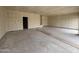 An oversized garage with unfinished walls and floors is ready for customizations and storage at 46886 W Coe St, Maricopa, AZ 85139