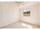 This bedroom includes a ceiling fan, tile flooring, and a view to the exterior at 5529 W Virginia Ave, Phoenix, AZ 85035