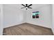 Clean bedroom with white walls, a ceiling fan and wood floors at 6038 E Hobart St, Mesa, AZ 85205