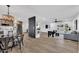 Spacious living room with hardwood floors, modern lighting, and stainless steel appliances in open-concept layout at 6038 E Hobart St, Mesa, AZ 85205