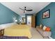 Bright bedroom with a teal accent wall, ceiling fan, and a cozy seating area at 6222 N 21St Dr, Phoenix, AZ 85015