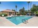 Community pool area with sparkling water, lounge chairs, and palm trees at 6222 N 21St Dr, Phoenix, AZ 85015