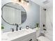 Updated bathroom features a round mirror, modern vanity, and shower with marble-style tile surround at 6565 N 19Th Ave # 45, Phoenix, AZ 85015