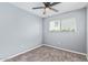 This bedroom features neutral carpet, a ceiling fan, and a window bringing in natural light at 6565 N 19Th Ave # 45, Phoenix, AZ 85015