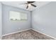 The simple bedroom has plush carpet, a ceiling fan, and a window bringing in natural light at 6565 N 19Th Ave # 45, Phoenix, AZ 85015
