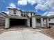 New home in construction phase with open garage, windows prepped for install and blue sky background at 7401 W Buckhorn Trl, Peoria, AZ 85383