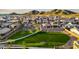 An aerial view of Aloravita community featuring the green common space and Gathering homes with mountain views at 7404 W Buckhorn Trl, Peoria, AZ 85383