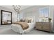 Bright bedroom with an ornate light fixture, shuttered windows, a large mirror, and stylish furnishings at 7404 W Buckhorn Trl, Peoria, AZ 85383