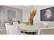 Chic dining room featuring a round table, neutral chairs, modern artwork, and stylish decor at 7404 W Buckhorn Trl, Peoria, AZ 85383