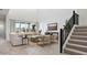 Bright living room with wood-look flooring, modern furnishings, a shiplap wall, and access to stairs at 7404 W Buckhorn Trl, Peoria, AZ 85383