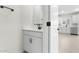 Bright bathroom featuring a modern vanity with sleek black fixtures and a glimpse into the adjacent kitchen at 7430 S 75Th Dr, Laveen, AZ 85339