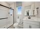 Modern bathroom showcasing a sleek glass shower, vanity with black accents, and natural light from a window at 7437 S 75Th Dr, Laveen, AZ 85339