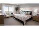 Bright bedroom featuring a comfortable bed, sitting area with a love seat, and a large window for natural light at 7437 S 75Th Dr, Laveen, AZ 85339
